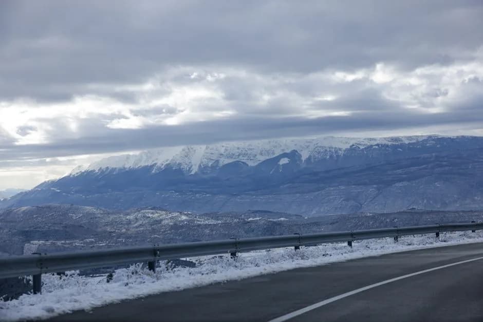 Carretera de montaña entre laderas nevadas